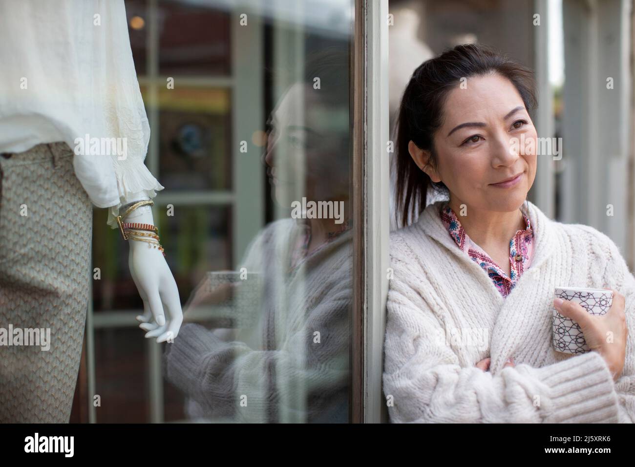 Donna sorridente e premurosa proprietaria del negozio con caffè all'aperto Foto Stock
