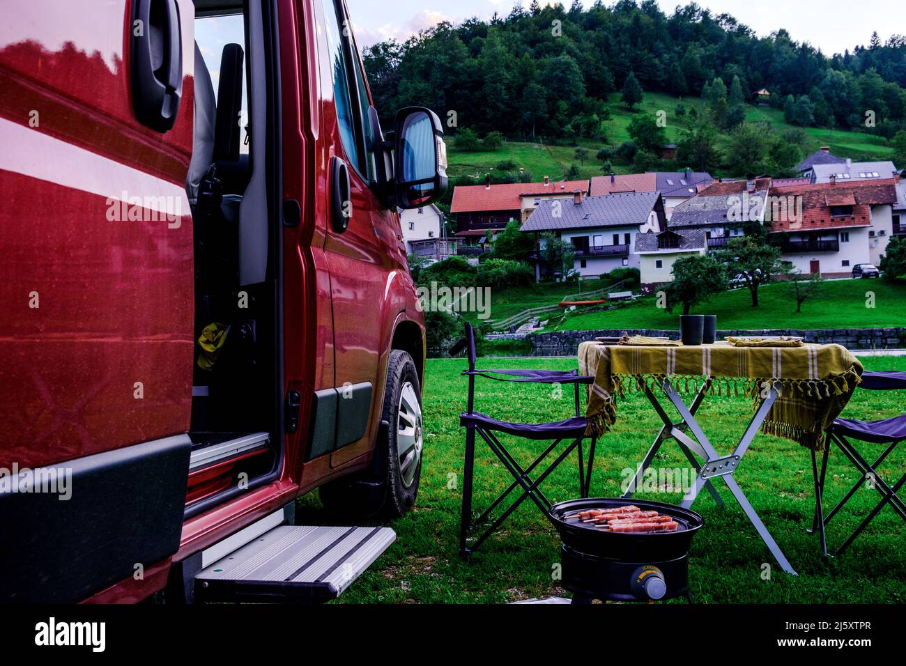 Camper rosso parcheggiato in un campo a Novo Mesto, Slovenia Foto Stock