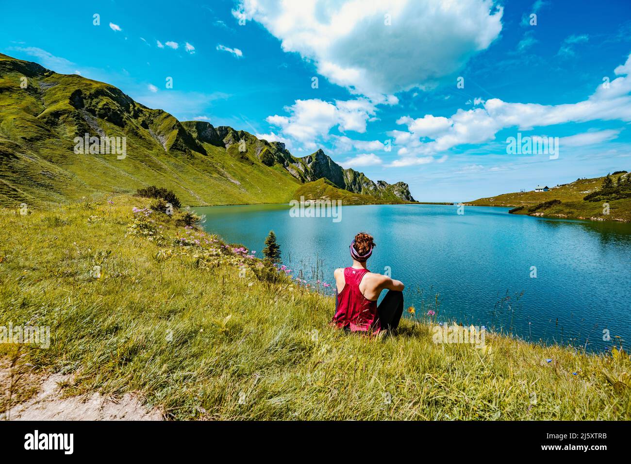 La donna gode di una splendida vista sullo Schrecksee nelle alpi bavaresi Foto Stock