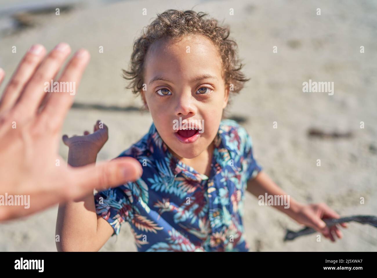 Ragazzo carino POV con sindrome di Down alta Fiving Foto Stock