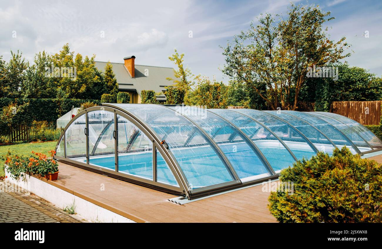 Area salotto in giardino. Piscina squisita con rivestimento trasparente. Foto Stock