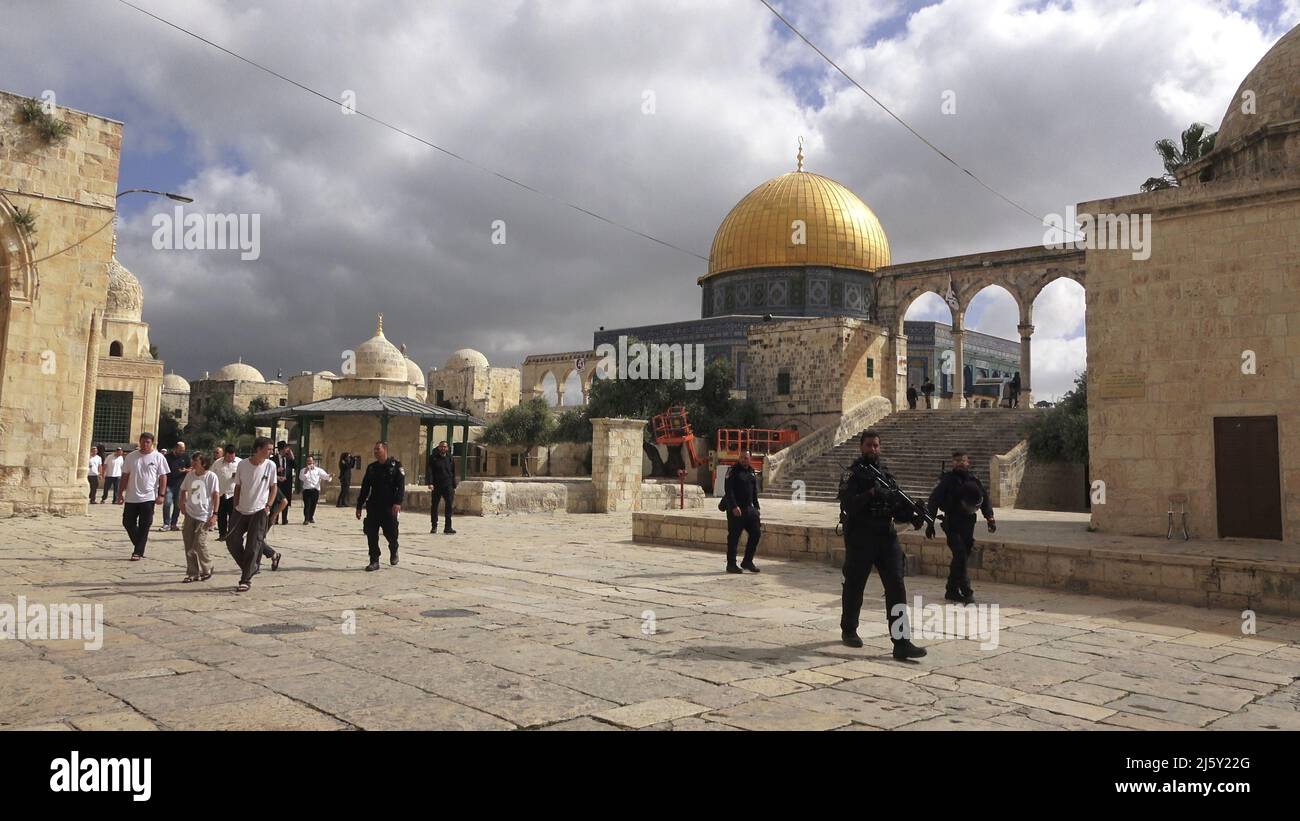 I poliziotti israeliani scortano un gruppo di ebrei religiosi che visitano il Monte del Tempio noto ai musulmani come Haram esh-Sharif (Santuario del Nobile) durante la festa di Pesach Ebraico (Pasqua) nella città vecchia il 20 aprile 2022 a Gerusalemme, Israele. Ebrei, cristiani e musulmani celebrano la Pasqua di quest'anno e il Ramadan nella stessa settimana, che ha causato tensioni tra palestinesi e israeliani, specialmente a Gerusalemme. Foto Stock