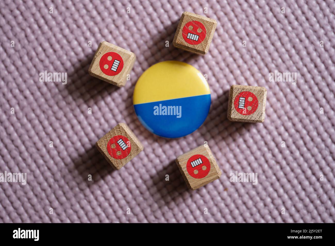 Badge con bandiera di Ucraina che giace tra emoticon male primo piano Foto Stock