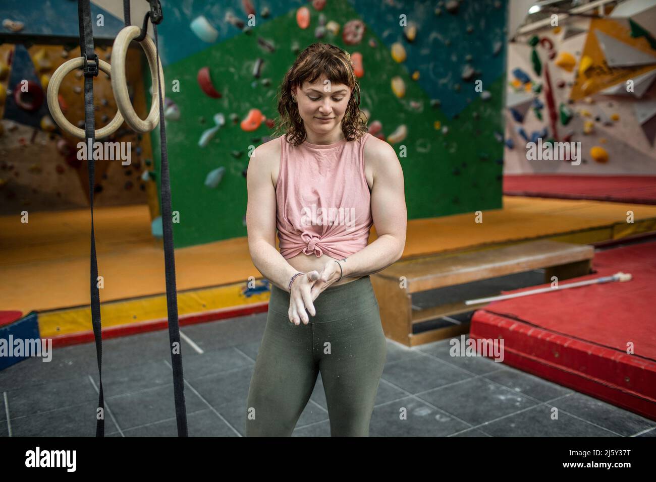 Giovane donna che si alza le mani sul muro di roccia Foto Stock