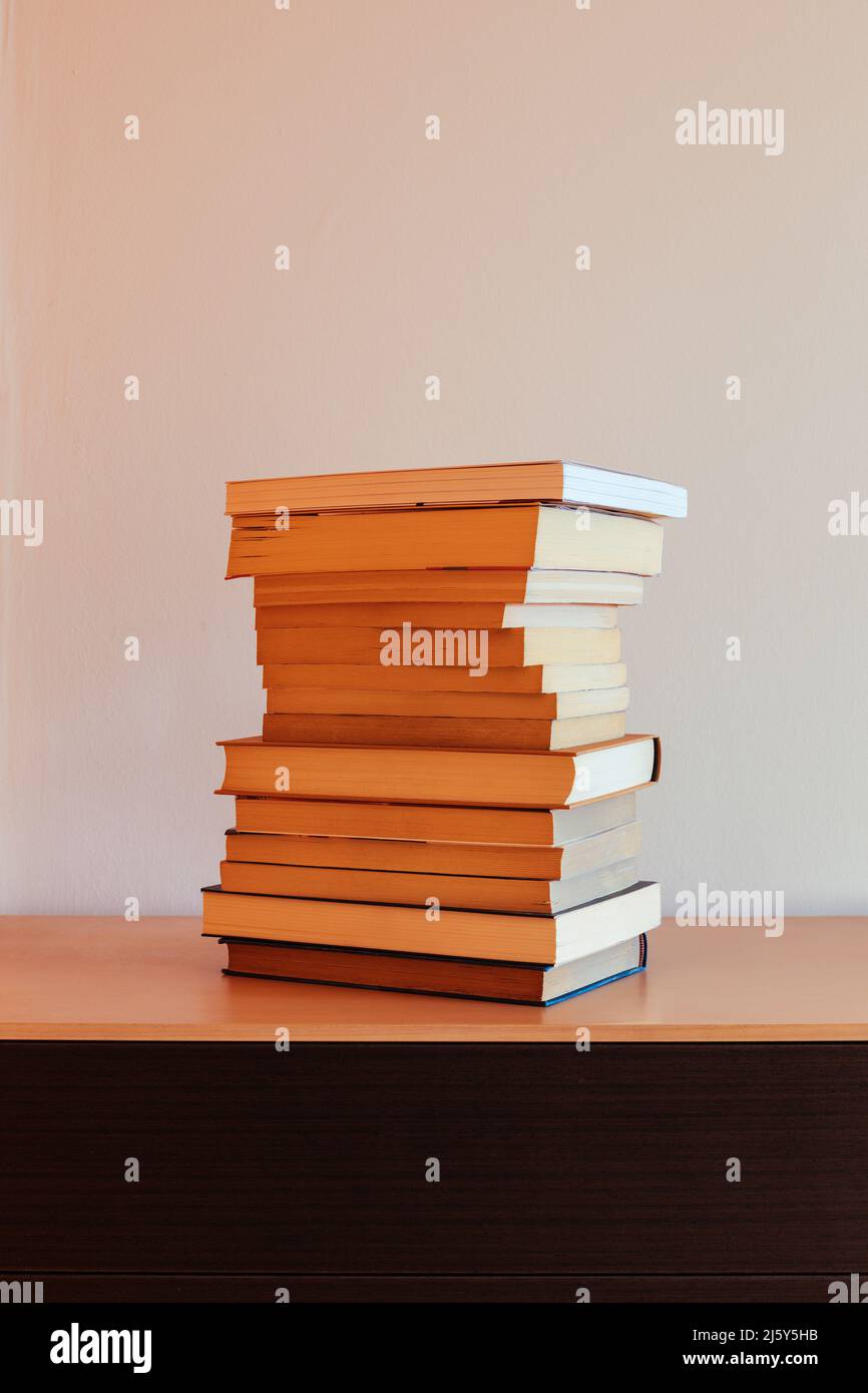 Vista frontale di un mucchio di libri su un mobile Foto Stock