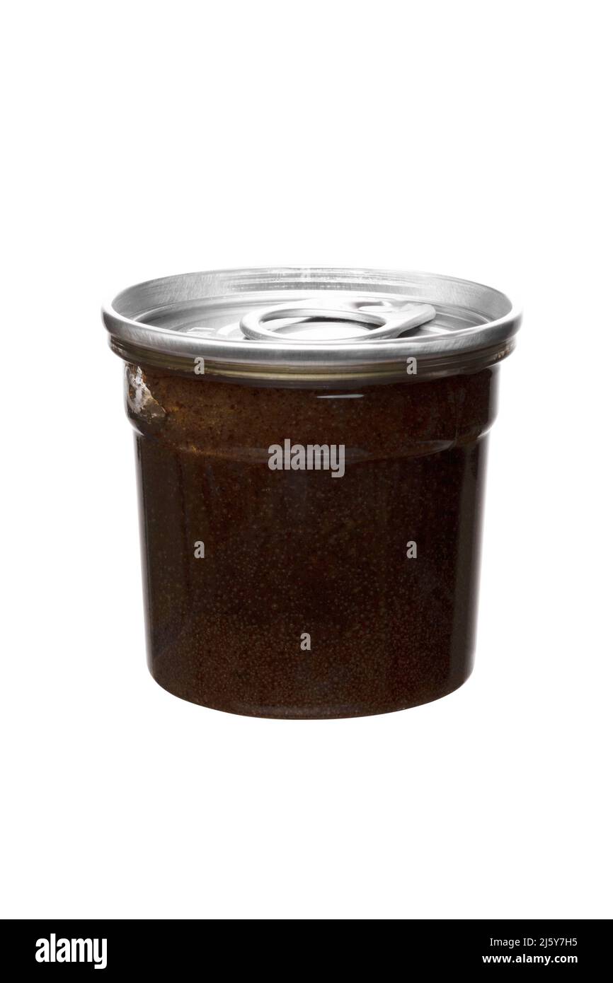scrub al caffè marrone in vaso trasparente con coperchio in metallo su sfondo bianco isolato Foto Stock