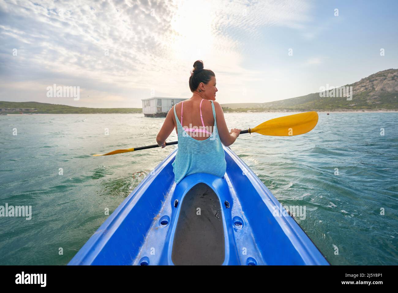 Donna con kayak al rospo sul lago estivo soleggiato Foto Stock