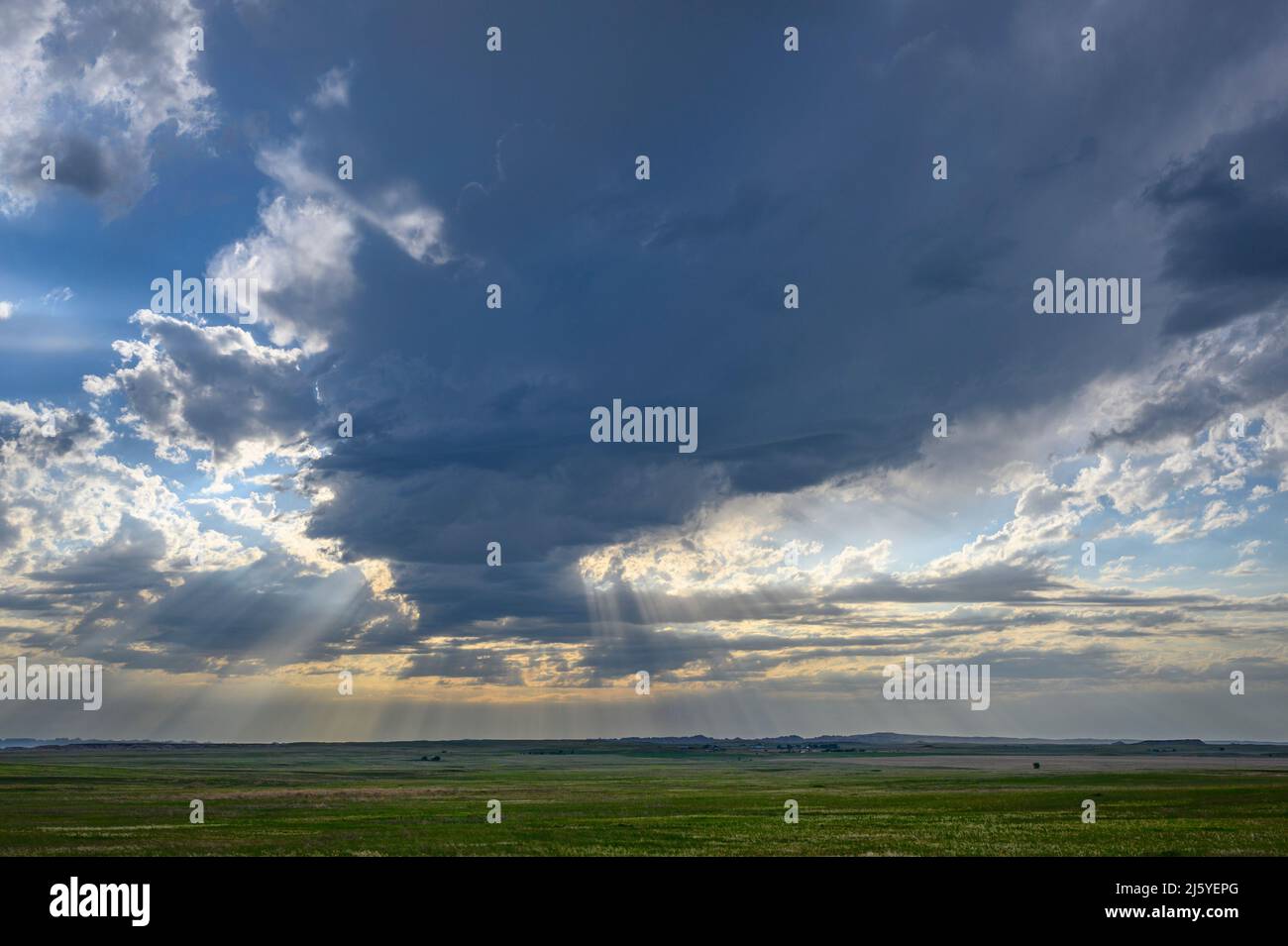 Raggi di Crepsucular e nuvole di tempesta sopra la prateria nel Badlands National Park, South Dakota Foto Stock