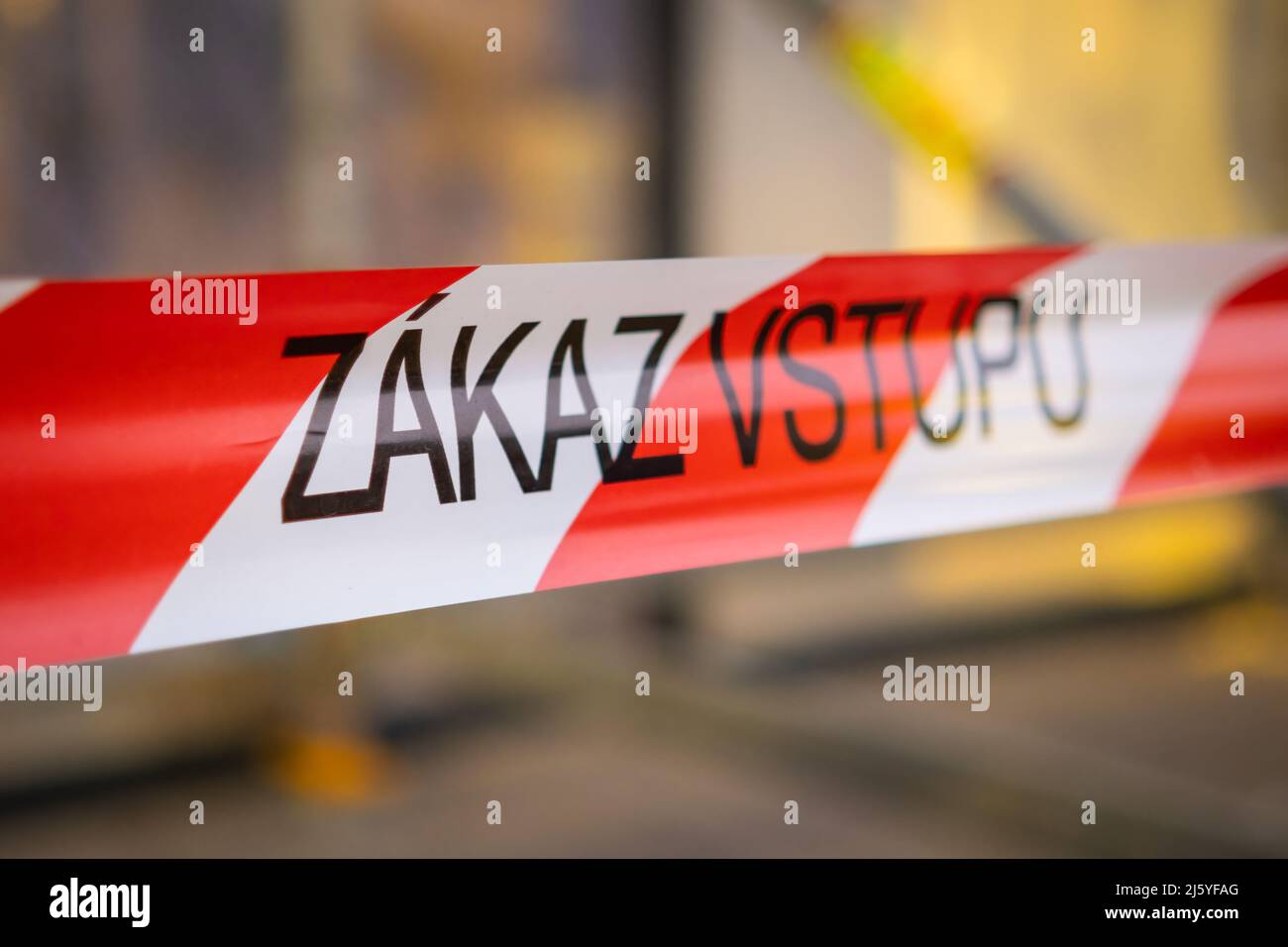 Segnala nastro rosso e bianco con iscrizione ceca Zakaz vstupu vieta l'ingresso al posto in città. Segnale di avvertimento sul primo piano di sfondo sfocato Foto Stock