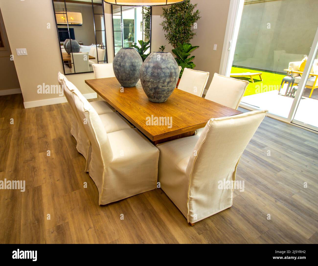 Sala da pranzo tavolo in legno con otto sedie con coprislip bianchi Foto  stock - Alamy