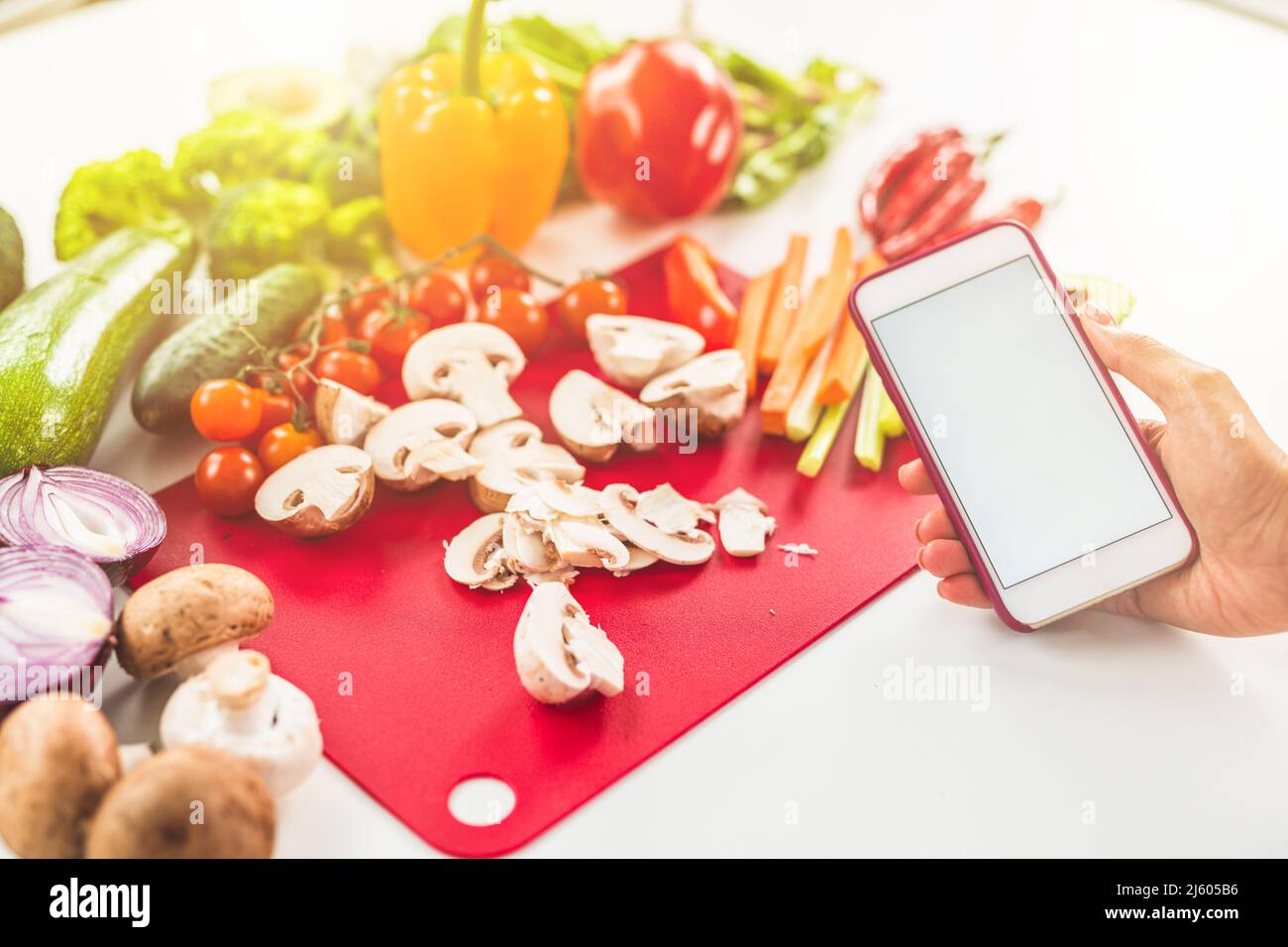 Cercate una ricetta su internet con il telefono cellulare a base di ingredienti vegetali Foto Stock