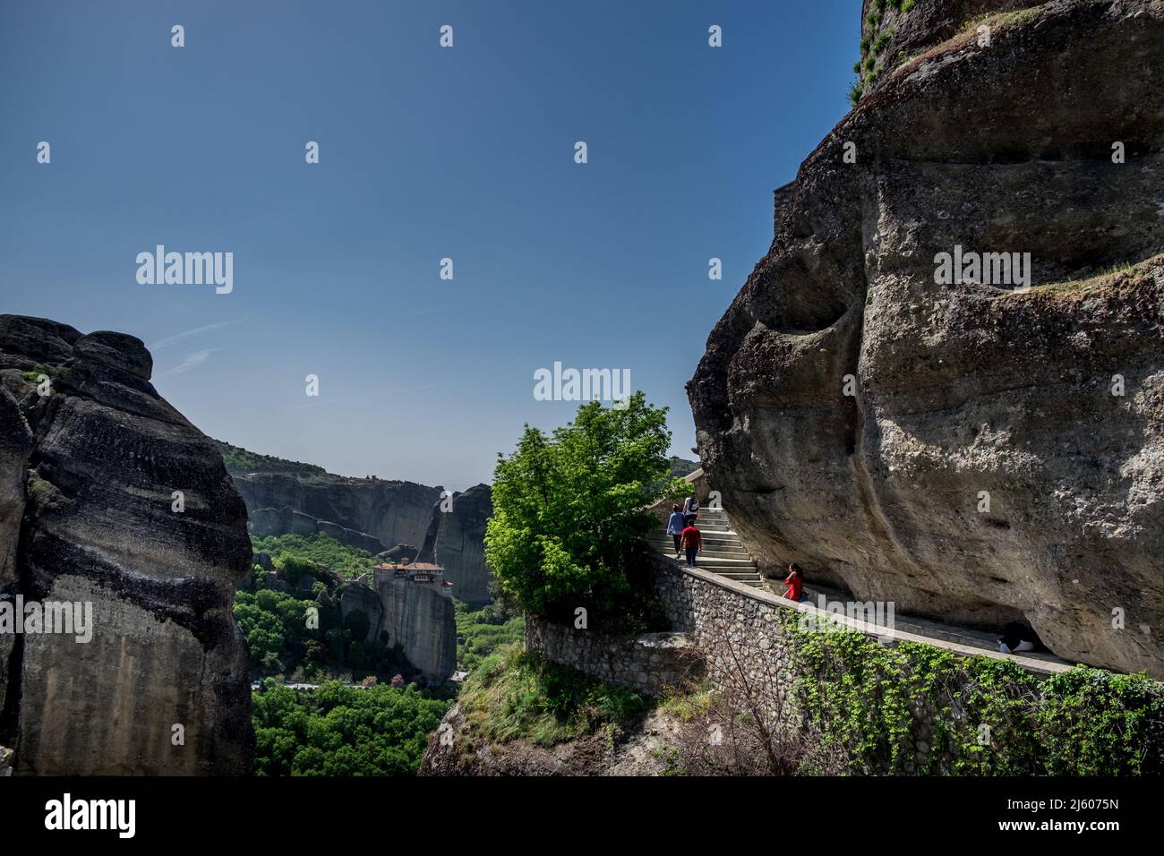 Le persone che salendo le scale tagliano in una roccia a Varlaam (Agioi Pantes) Monastero Meteora , Grecia Foto Stock