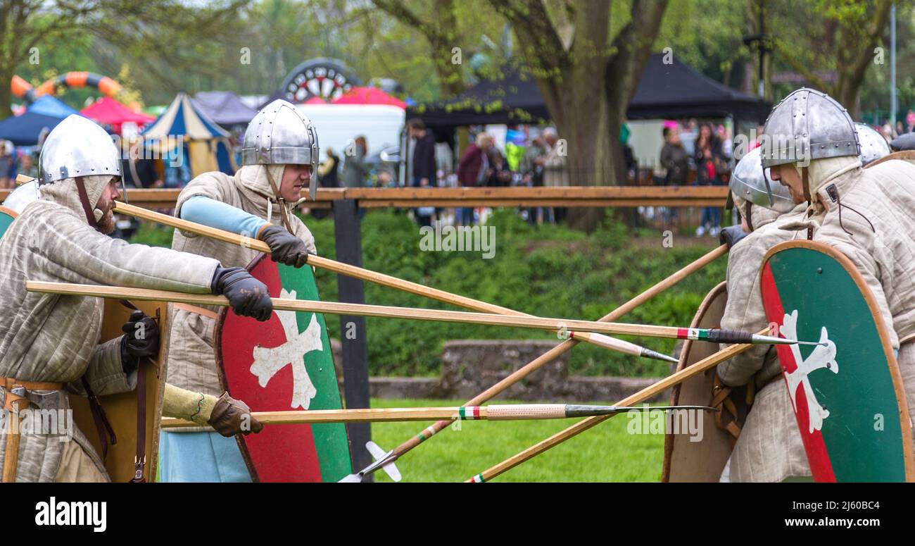 I Cavalieri vestiti in costume d'epoca si impegnano a combattere a mano in una rievocazione medievale. Foto Stock