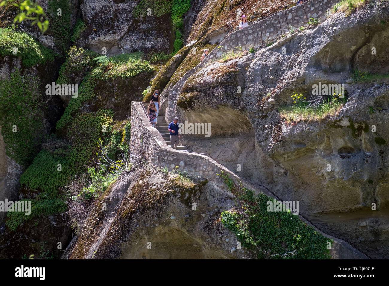 Le persone che salendo le scale tagliano in una roccia a Mtemorfosis Sotiros Monastero Meteora , Grecia Foto Stock
