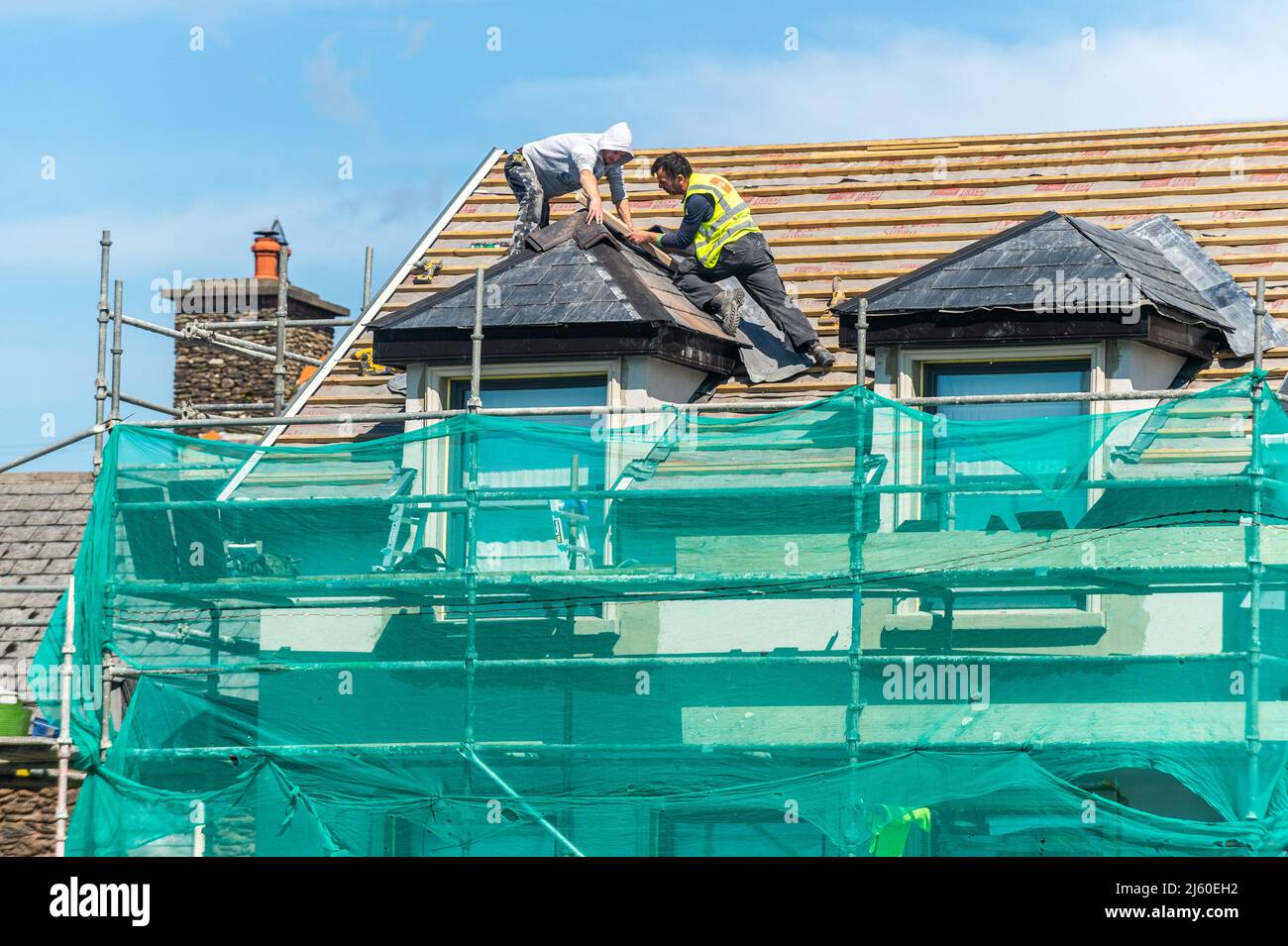 Roofers su impalcatura tegola un tetto domestico in Dingle, contea di Kerry, Irlanda. Foto Stock