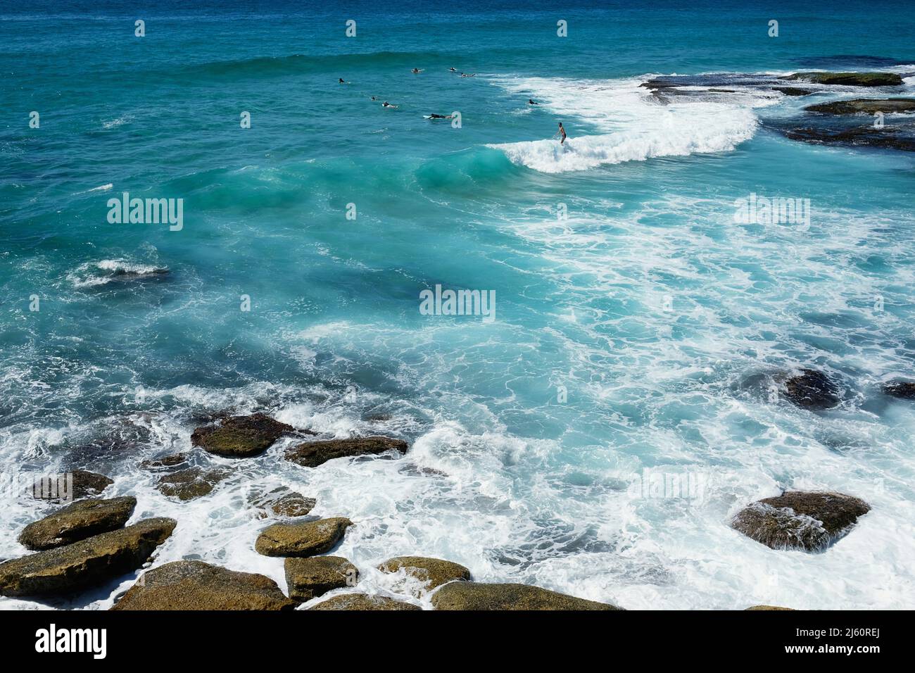 Surfisti che cavalcano le onde a Tamarama Beach, sulla costa orientale di Sydney, nuovo Galles del Sud, Australia Foto Stock