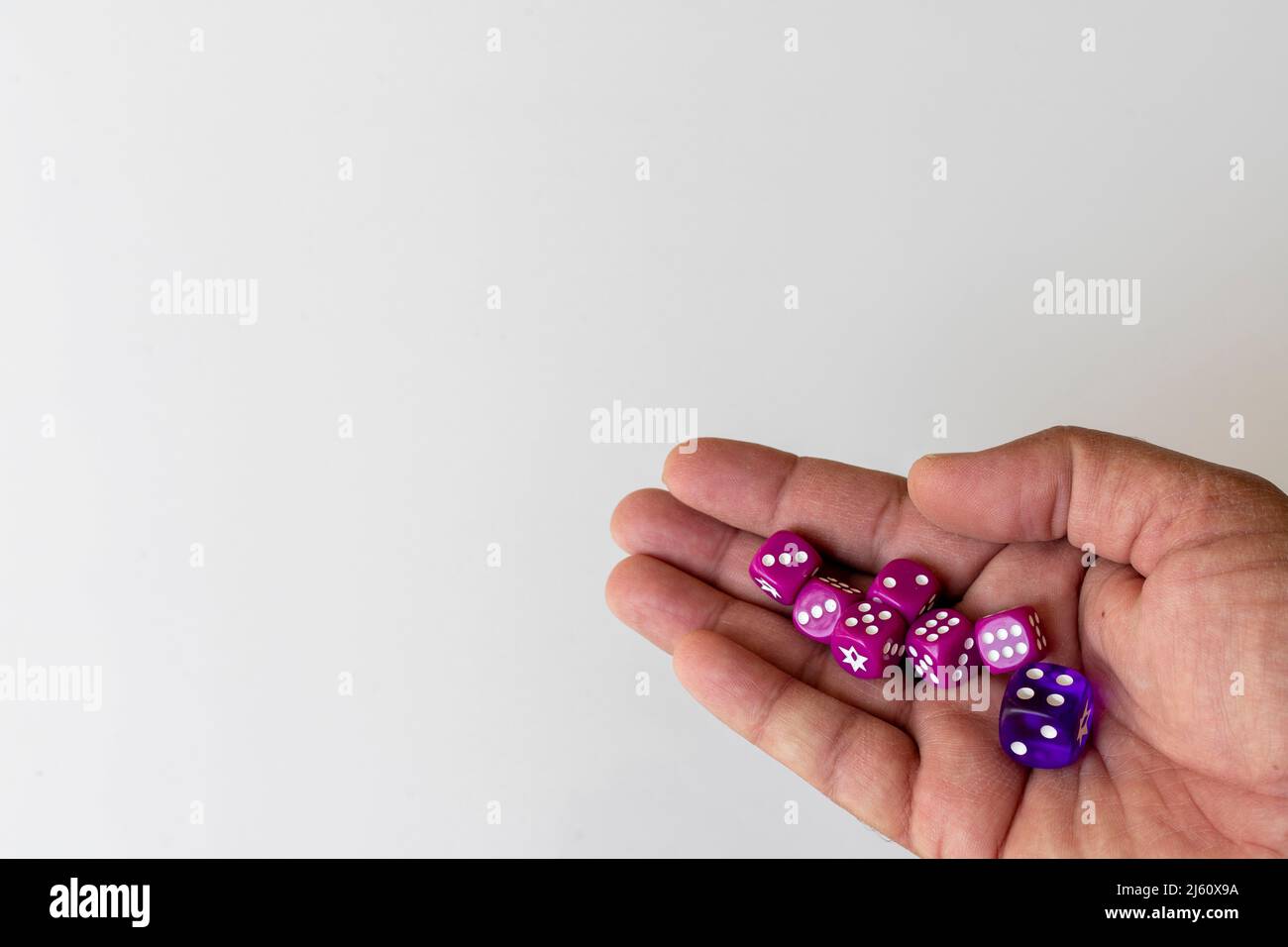 Tenere i dadi in mano con uno sfondo bianco isolato Foto Stock