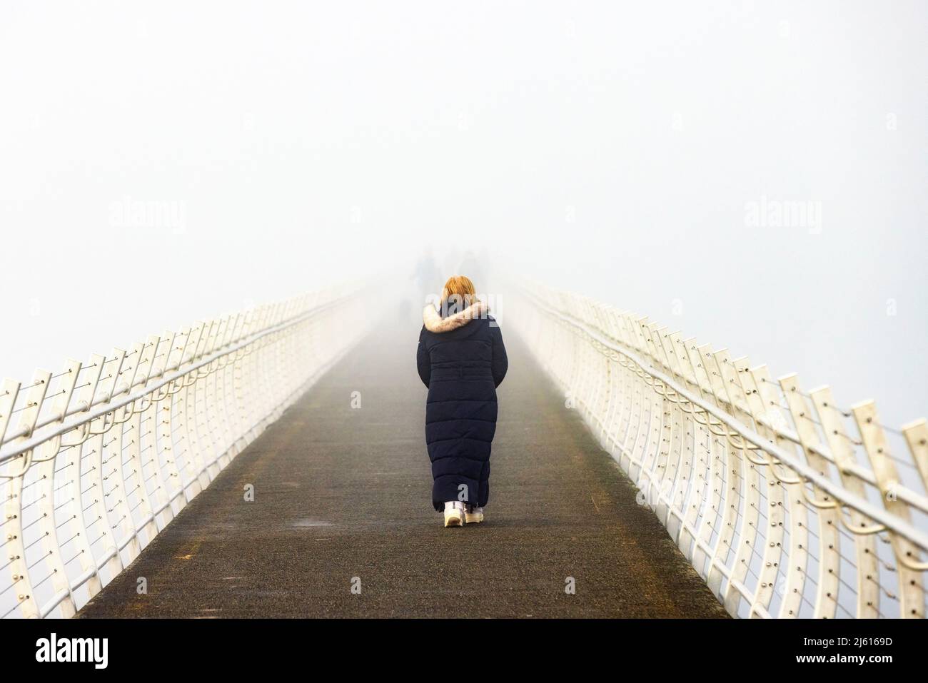Donna che cammina in una fredda e nebbia mattina sul punto Ogden Breakwater - Victoria, Vancouver Island, British Columbia, Canada Foto Stock