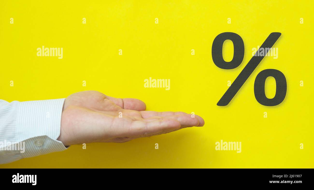 La mano mostra le percentuali su sfondo giallo. Foto Stock