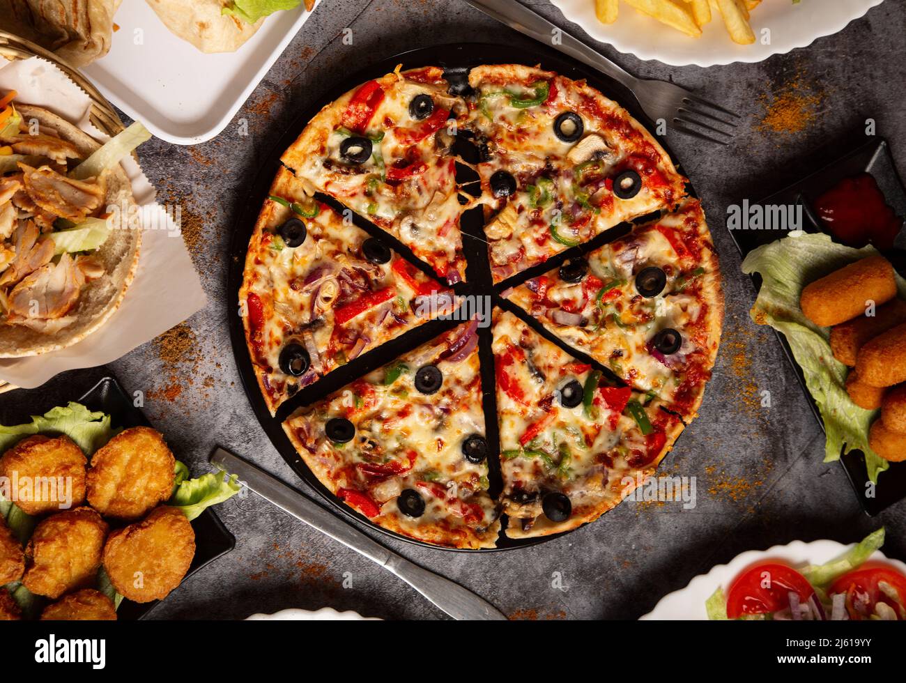 Vista dall'alto di una pizza di verdure a fette e diversi piatti assortiti Foto Stock
