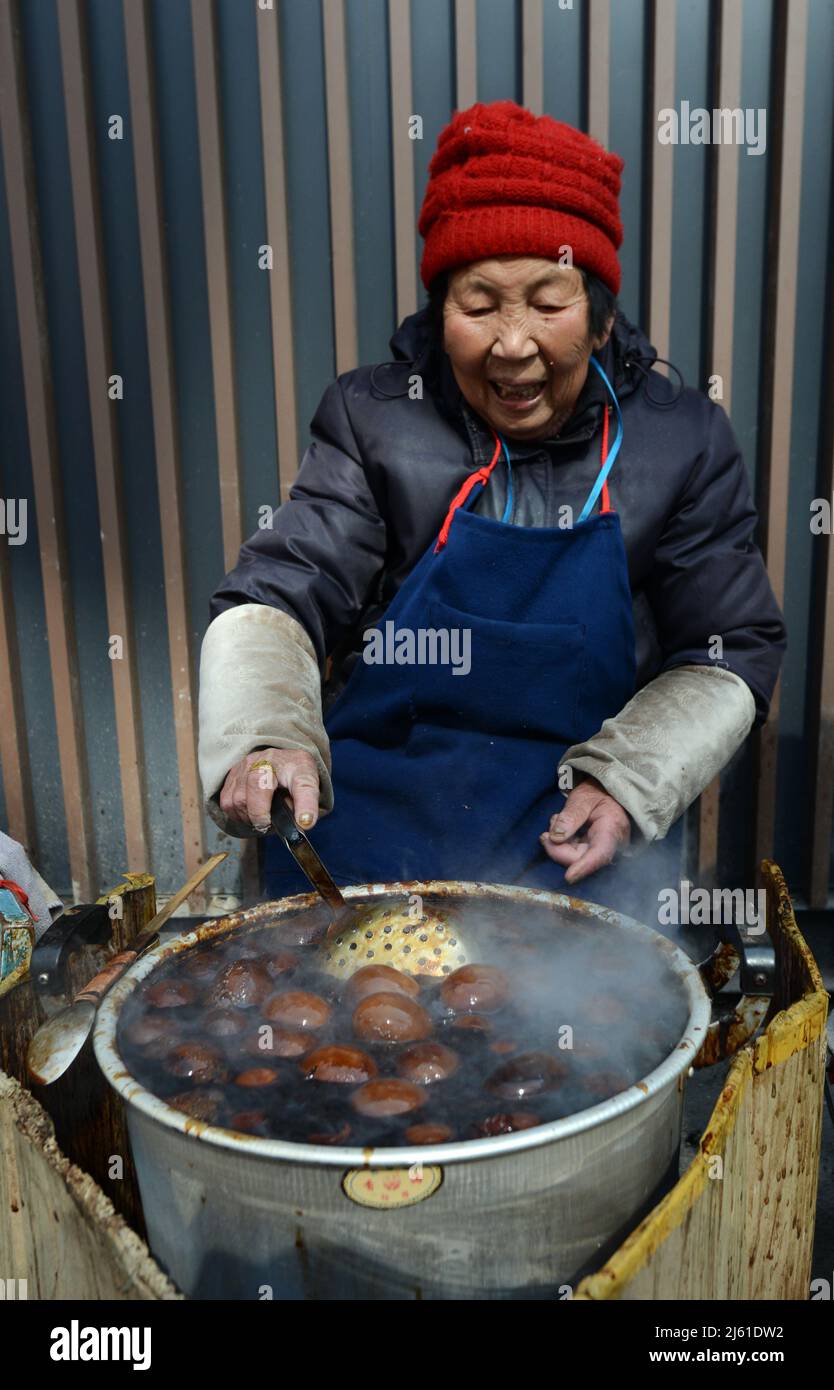 Una donna locale che cucinava uova tradizionali di foglie di tè. Le uova sono cotte in tè, salsa di soia e altre spezie e sono un comune in tutta la Cina. Foto Stock