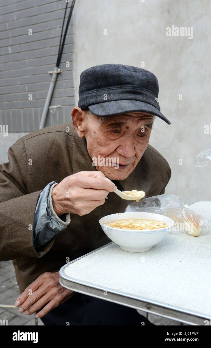 Gusterete una ciotola di zuppa di noddle a colazione. Nanjing, Cina. Foto Stock