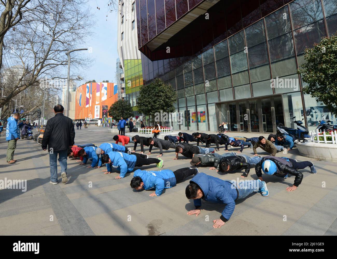 Personale del Maoye World Center che fa il loro esercizio mattutino come parte di una routine disciplina. Nanjing, Cina. Foto Stock