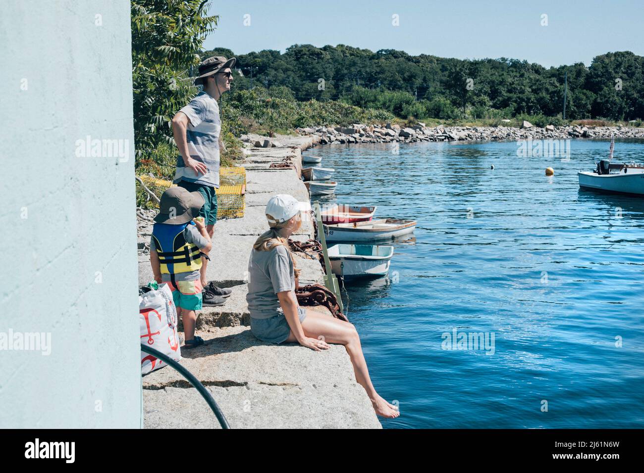La famiglia al bordo che aspetta insieme nella giornata di sole Foto Stock