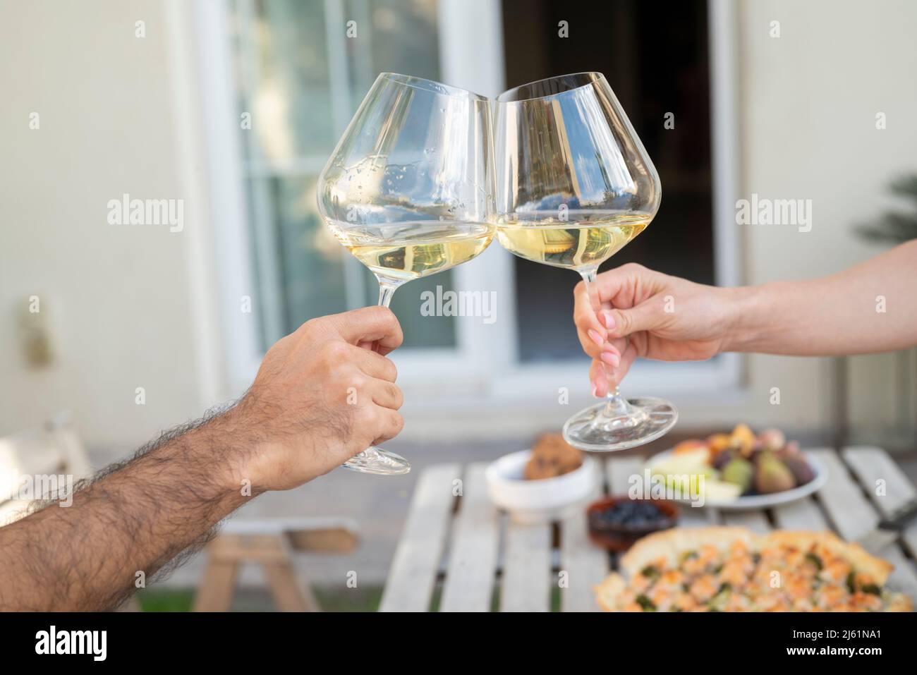 Mani di coppia tostatura con wineglasses in giardino Foto Stock
