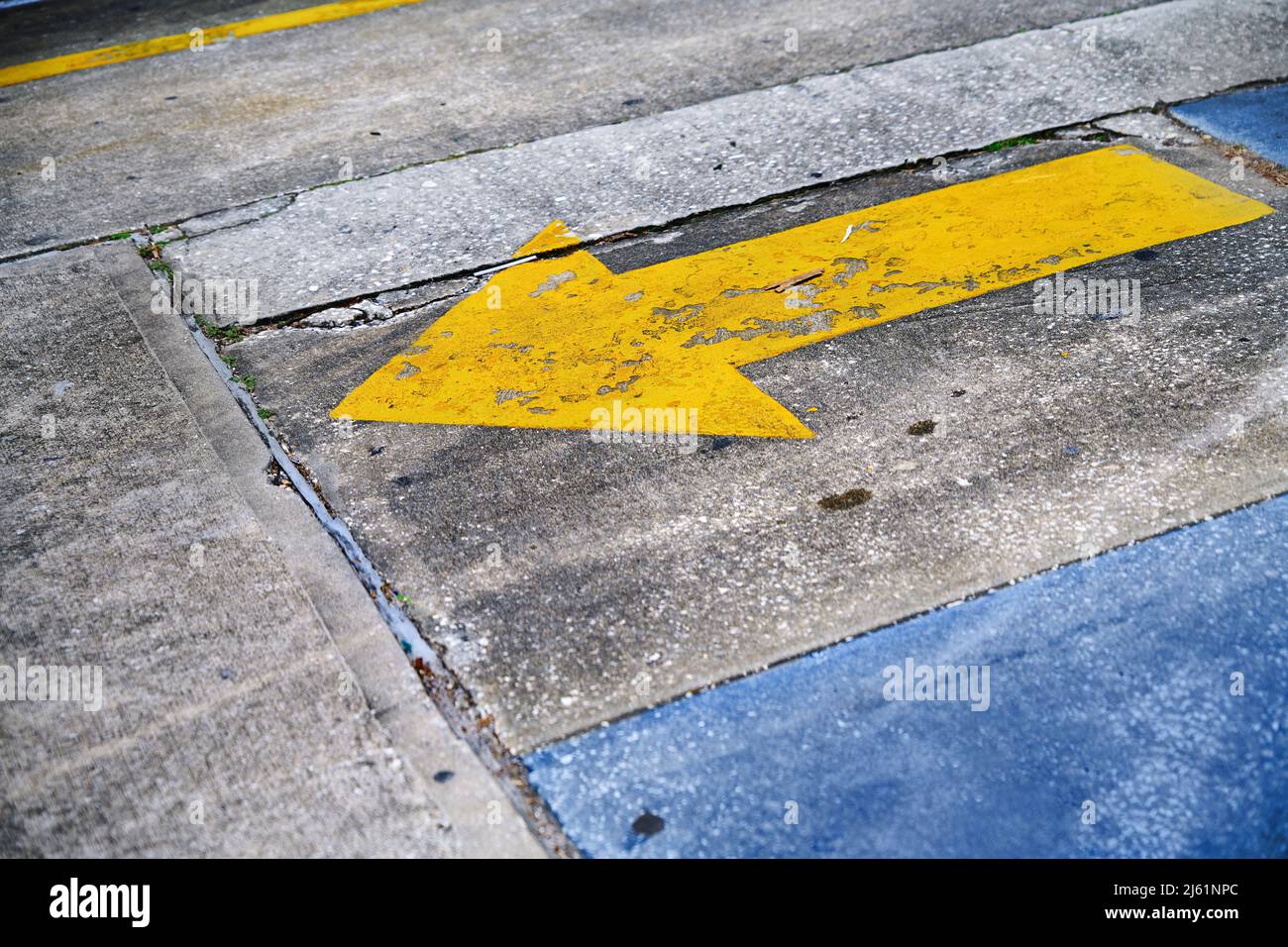 Simbolo freccia giallo su strada Foto Stock