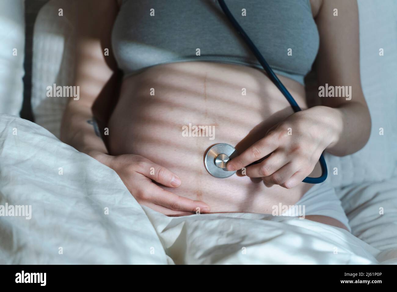 La donna incinta ascolta il battito cardiaco del bambino e i movimenti con  uno stetoscopio o fetoscopio