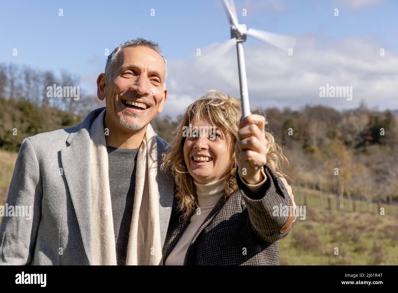 Coppia matura felice guardando il modello di turbina eolica Foto Stock