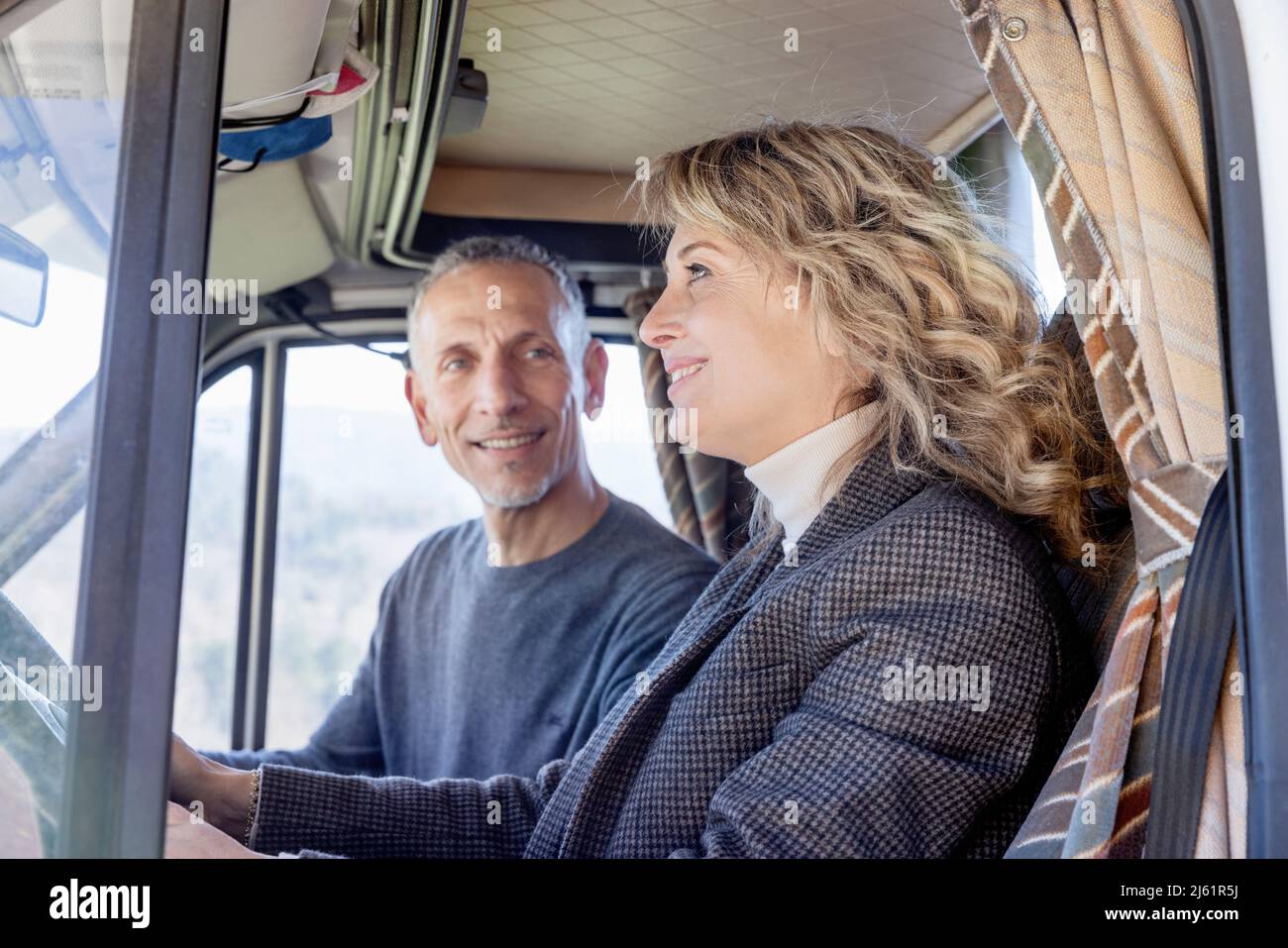 Donna che guida un camper con un uomo in viaggio su strada Foto Stock