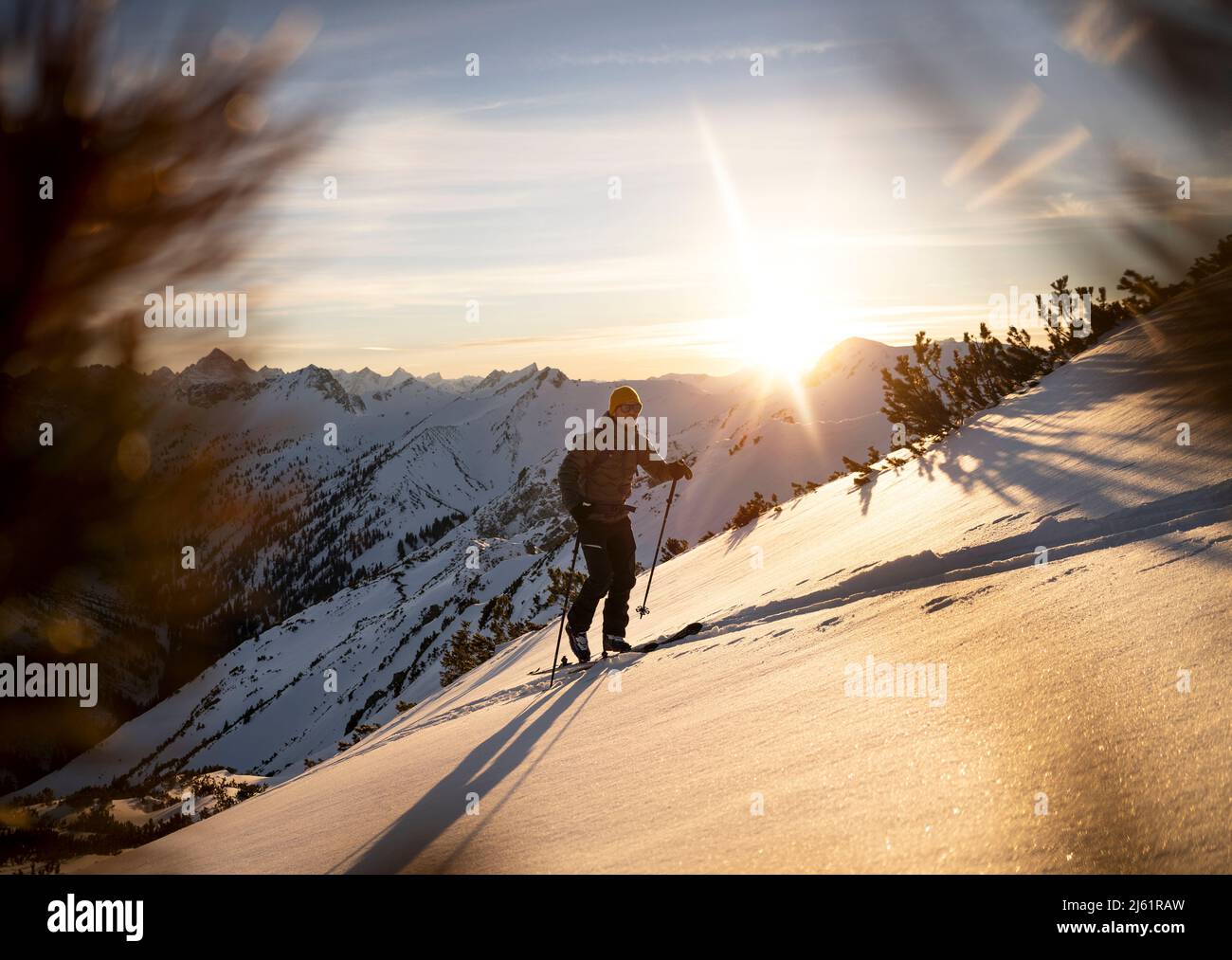 Uomo con sci pole a piedi su una montagna innevata Foto Stock