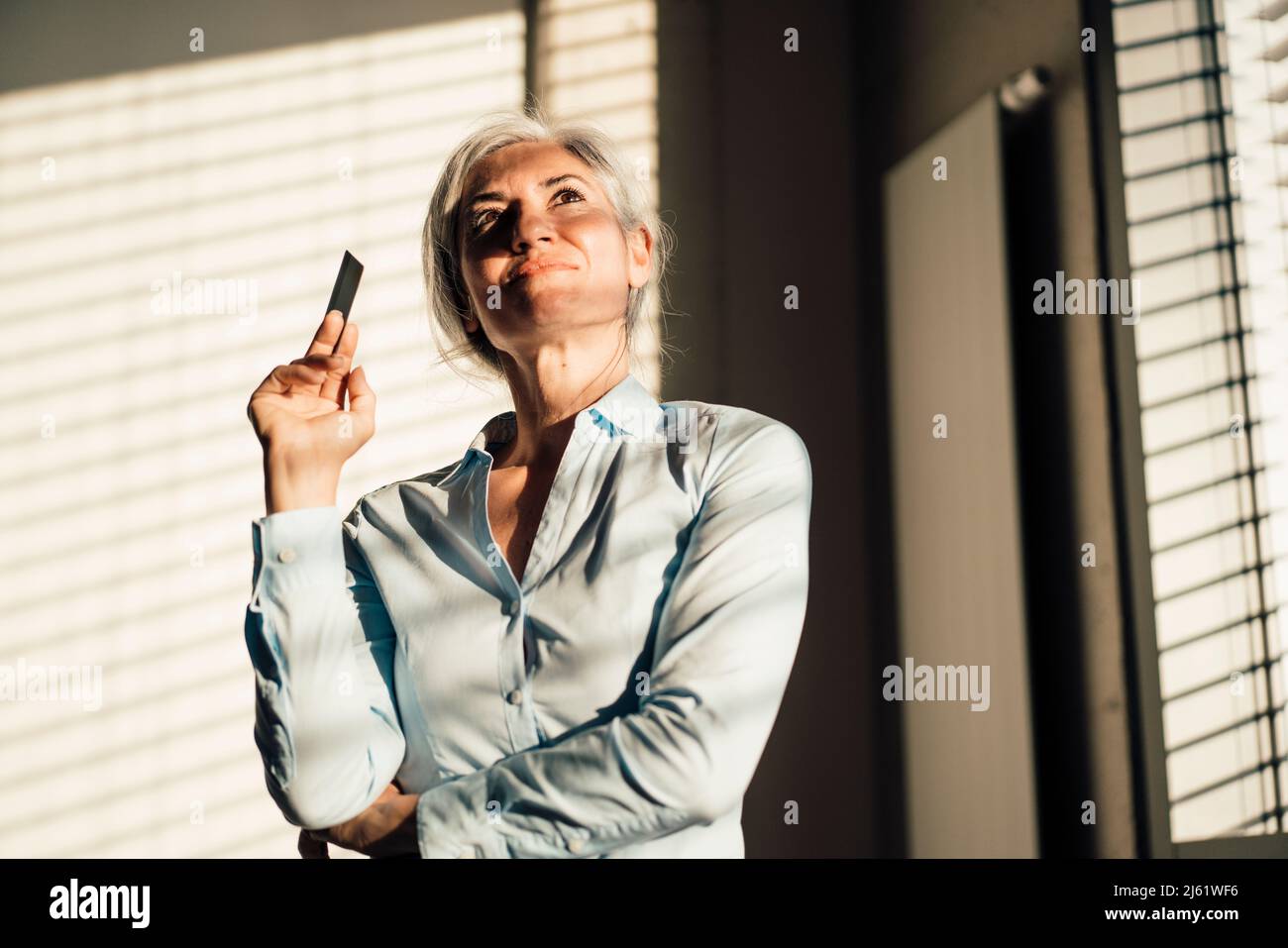 Un uomo d'affari premuroso con carta di credito in ufficio Foto Stock