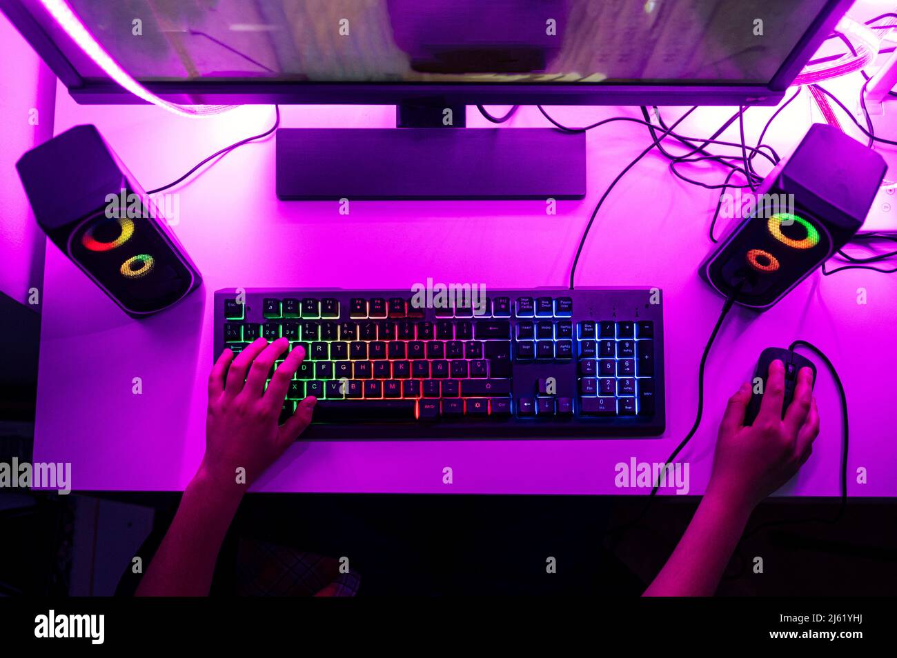 Ragazzo con la tastiera del computer e il mouse che gioca al computer Foto Stock