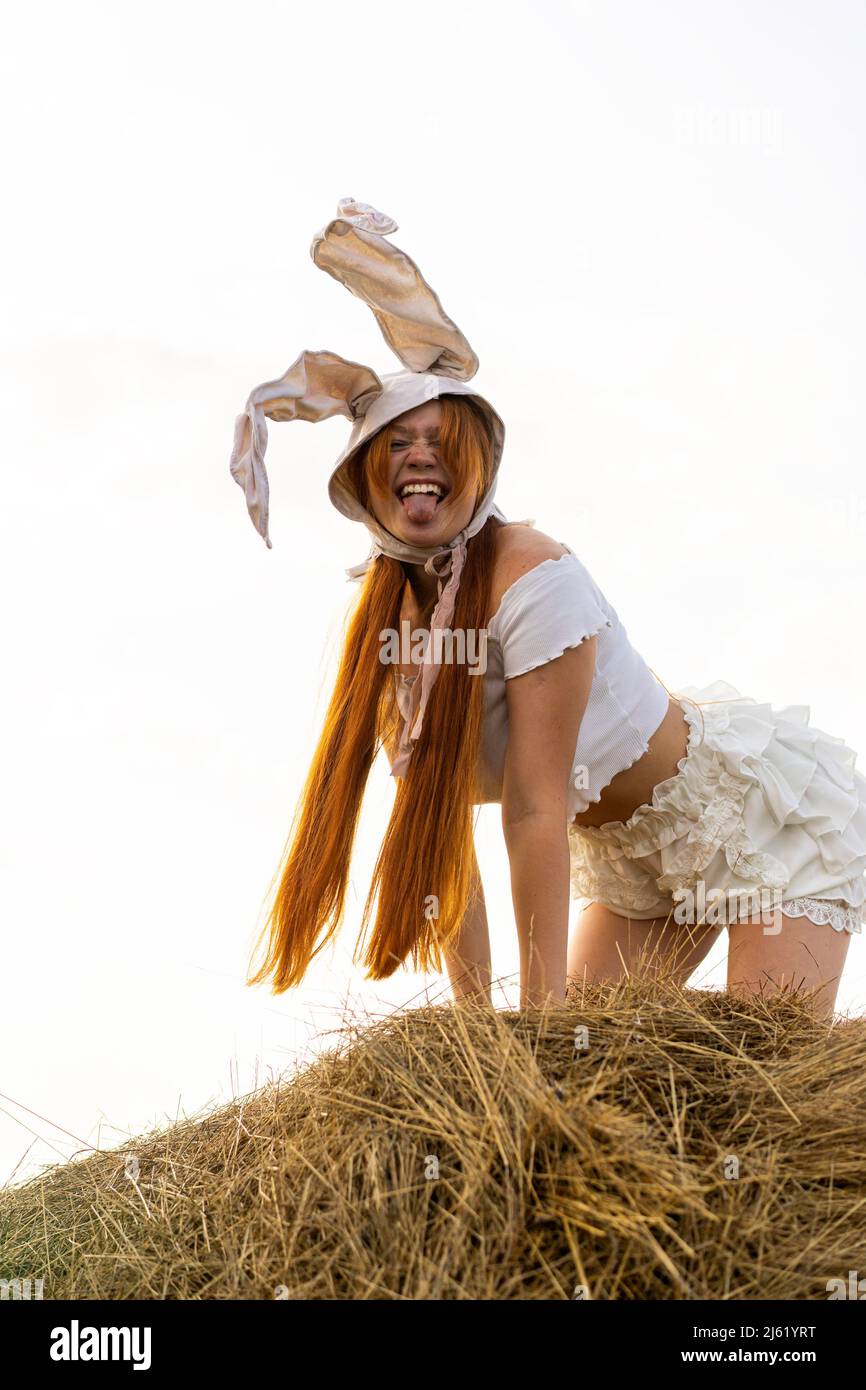 Giocosa giovane donna che indossa il costume di coniglio che mostra la lingua Foto Stock