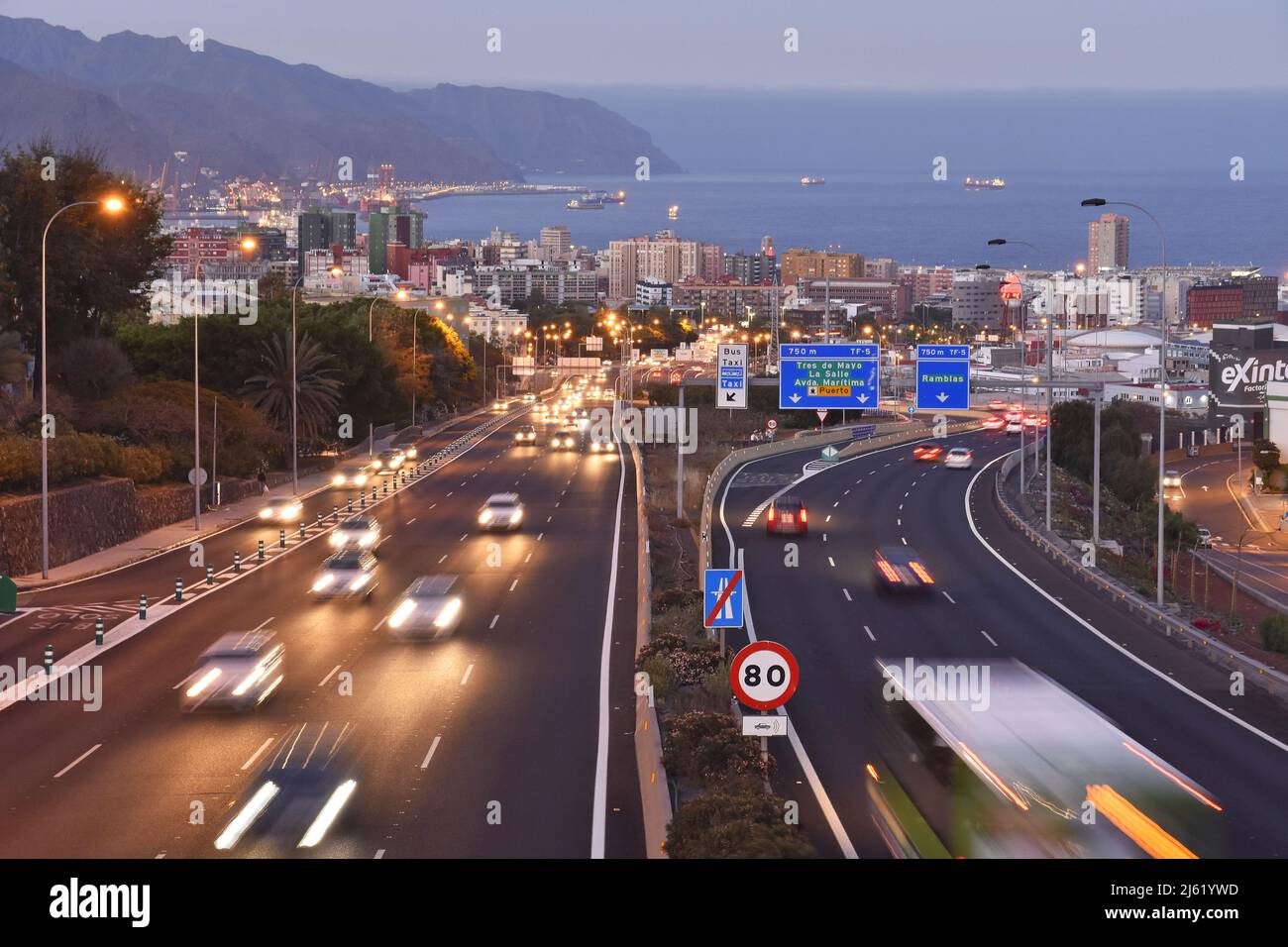 Autostrada Autopista TF-5 che si avvicina alla città di Santa Cruz de Tenerife al crepuscolo, Isole Canarie Spagna. Foto Stock