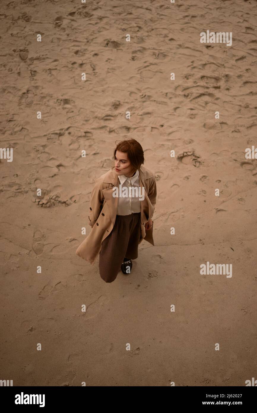 Giovane donna in piedi sulla sabbia in spiaggia Foto Stock