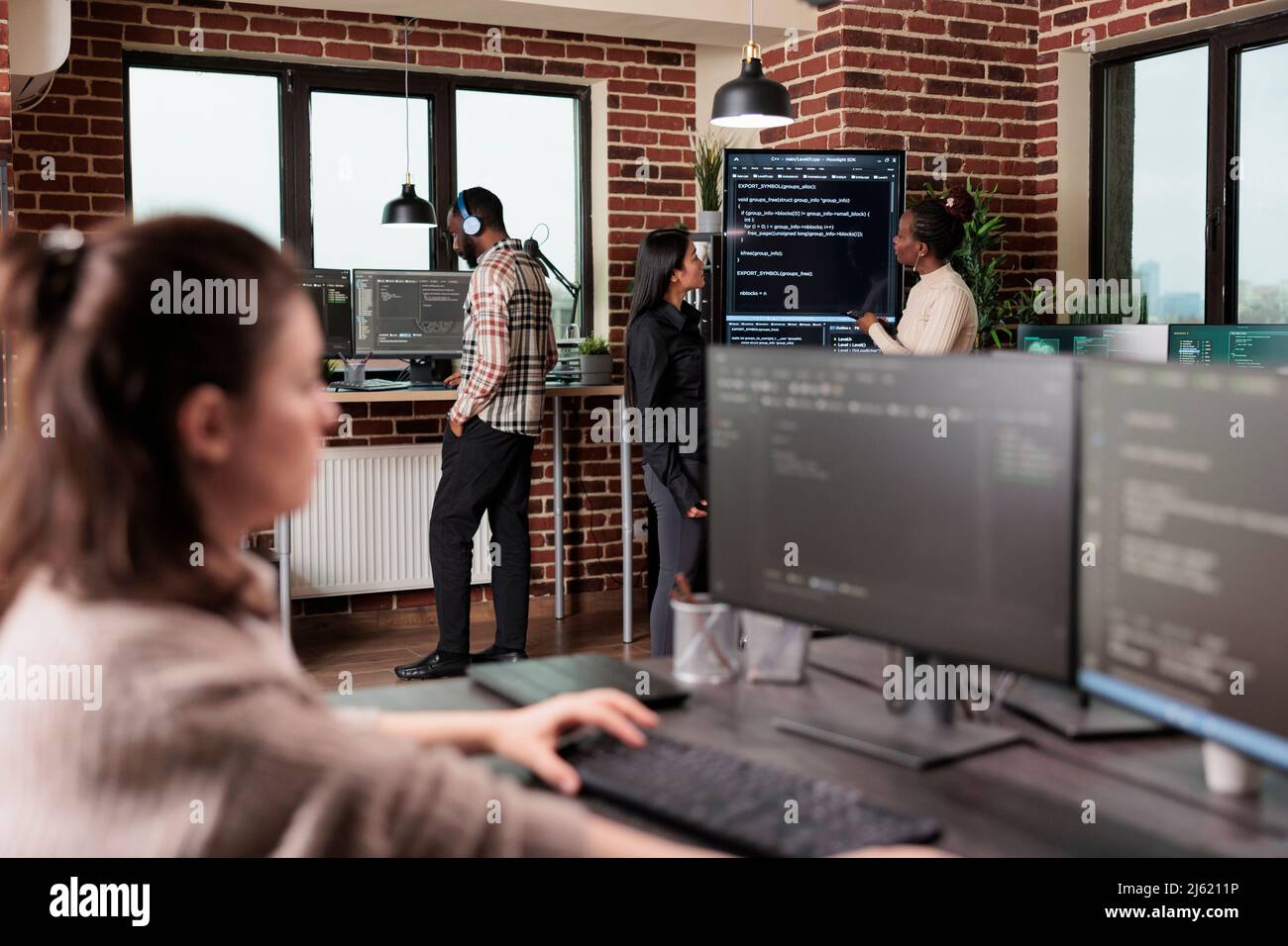 Team che sviluppa livelli aggiuntivi di sicurezza per sostenere una buona funzionalità del sistema. Sviluppatori di reti miste di race back-end che analizzano il metodo di elaborazione cloud del database di interfaccia. Foto Stock