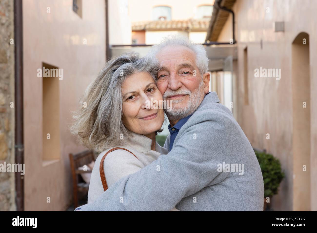 Una coppia di anziani allegri si abbracciano nel cortile dell'hotel Foto Stock