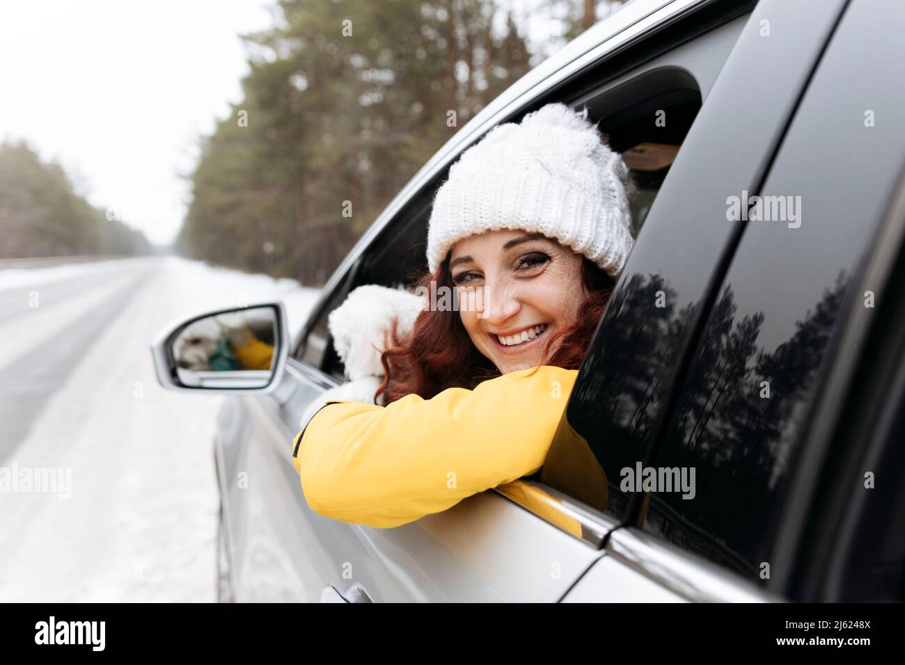 Donna felice guardando fuori della finestra auto Foto Stock