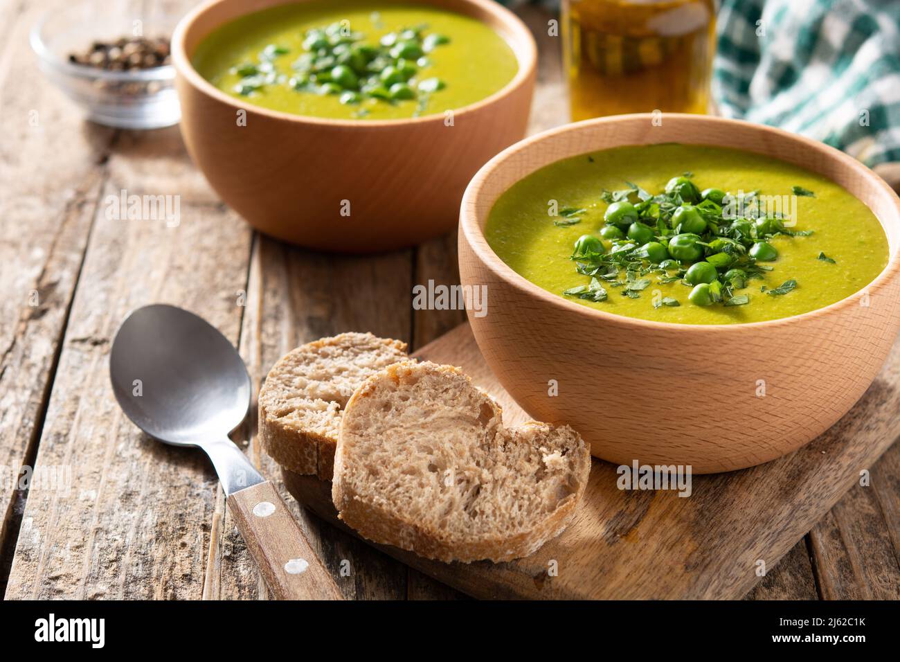 Zuppa di piselli verdi in una ciotola su un rustico tavolo di legno Foto Stock