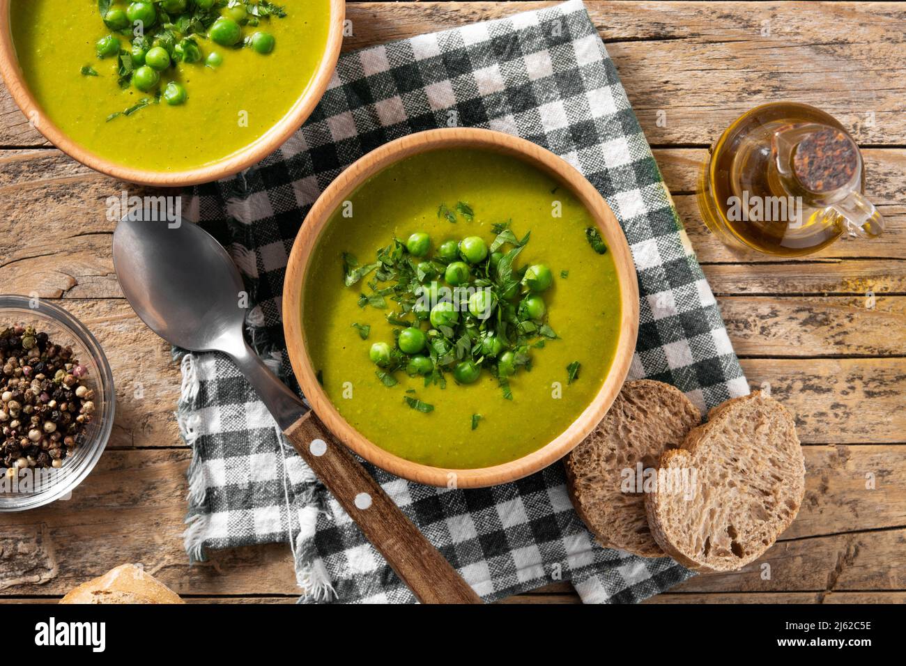 Zuppa di piselli verdi in una ciotola su un rustico tavolo di legno Foto Stock