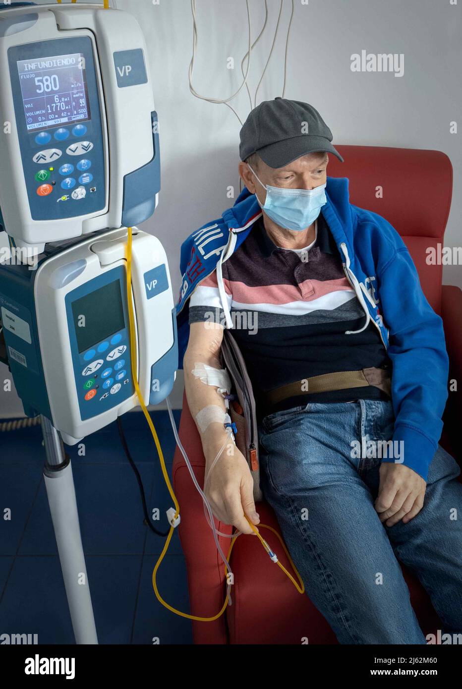 Uomo seduto in camera per chemioterapia, Foto Stock