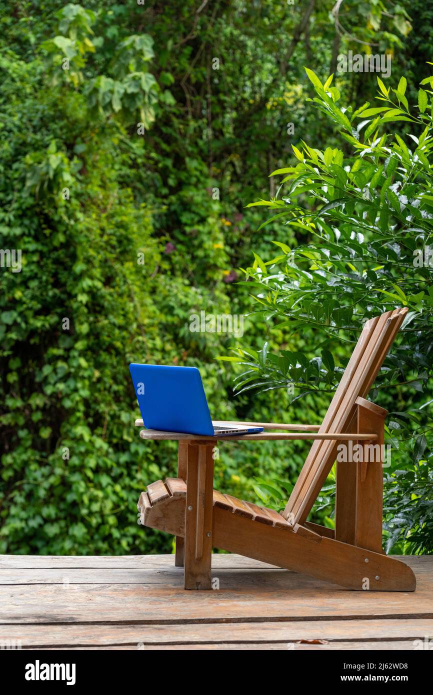 Un computer portatile su una sedia Adirondack in un Lodge della foresta pluviale, Digital Nomad Concept, provincia di Chiriqui, Panama, America Centrale Foto Stock