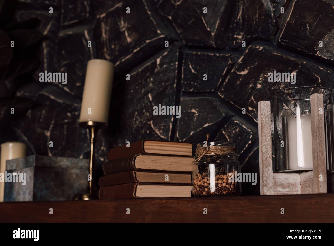 Ripiano in legno con libri, candele e altri articoli impilati Foto Stock