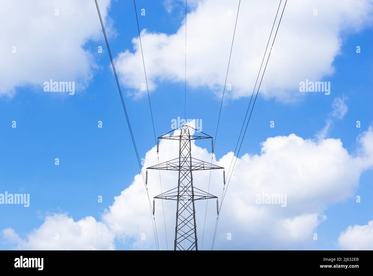 Elettricità pilone rete nazionale fornitore di energia elettrica contro un cielo blu soffice bianco nuvole Inghilterra GB Regno Unito Europa Foto Stock