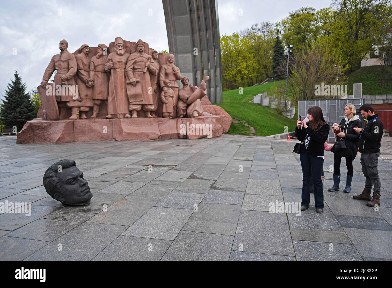 Ucraina. Kyiv, 26 Apr 2022, Una donna ha visto scattare foto di smantellare il monumento dell'Unione sovietica che simboleggia l'amicizia ucraino-russa a causa della continua invasione della Russia dell'Ucraina. Il 25 aprile 2022, il sindaco di Kiev vitali Klitschko ha annunciato la rimozione del monumento dell'Unione Sovietica nel centro di Kiev. Questo monumento eretto nel 1982 come simbolo della riunificazione di Ucraina e Russia durante l'era del governo sovietico. La statua di due uomini che detengono una medaglia rappresenta l'Ordine di amicizia dei popoli dell'Unione Sovietica, mentre l'arco arcobaleno è chiamato l'Arco dell'amicizia del popolo. Aggiunta Foto Stock