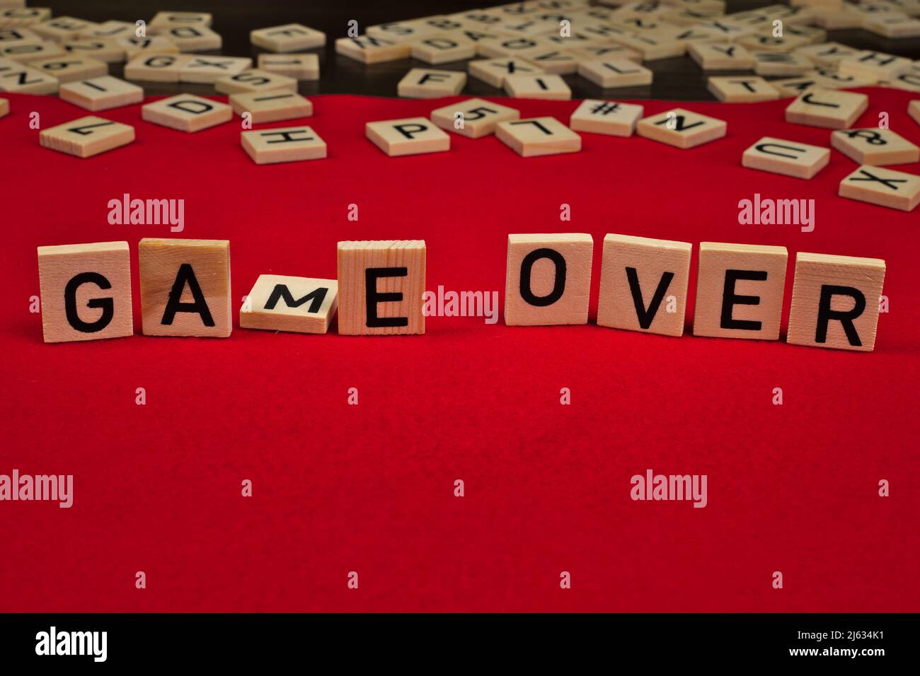 Frase 'Game Over' composta da tavole di legno con lettere su sfondo rosso feltro Foto Stock